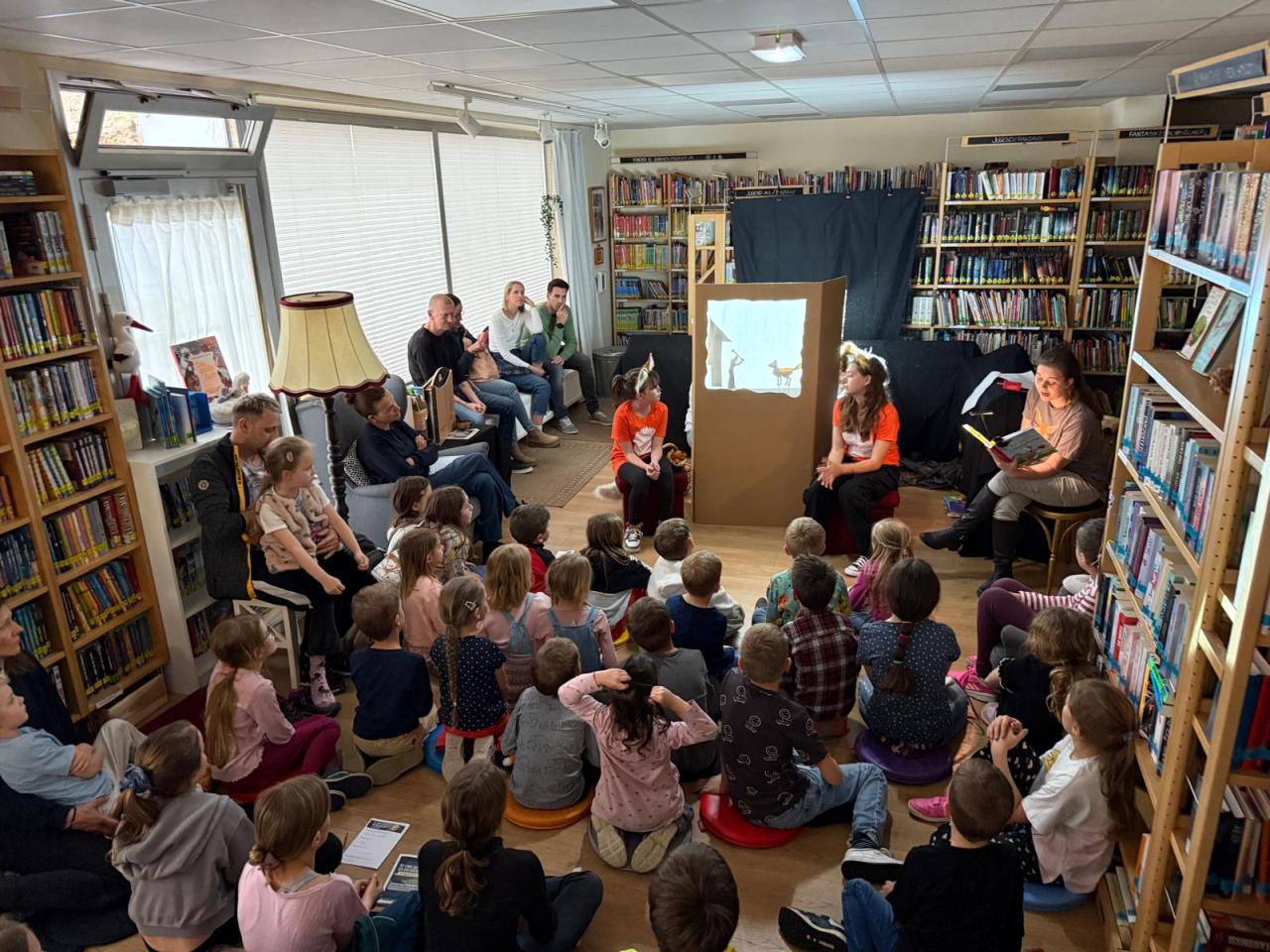 Kinder sitzen am Boden uns verfolgen das Schattentheater der Aiserkids