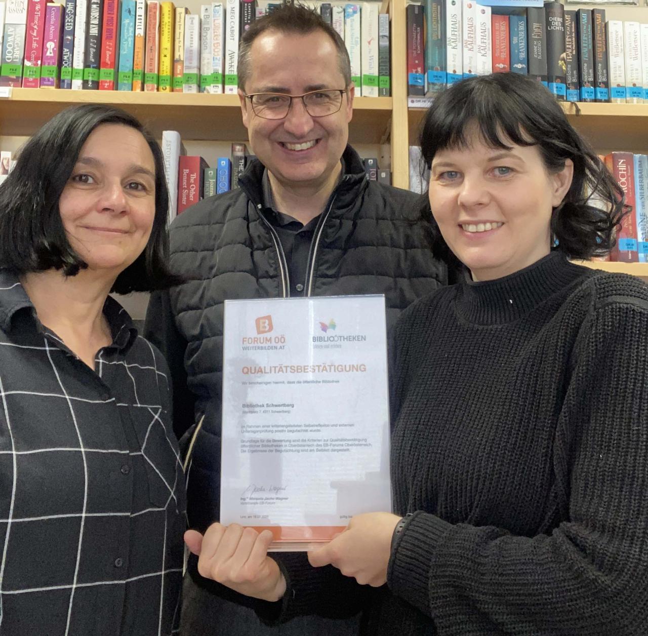 Die beiden Bibliothekarinnen mit dem Bürgermeister und der Urkunde