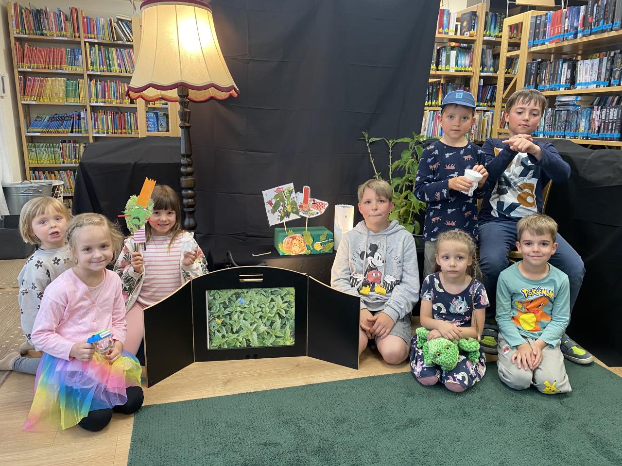 einige Kinder sitzen am Boden neben Brennnesseln