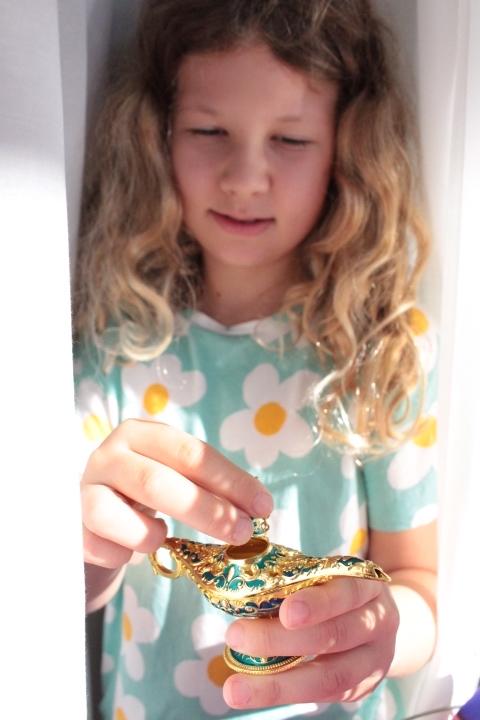 ein Mädchen hält eine Miniatur-Wunderlampe in der Hand