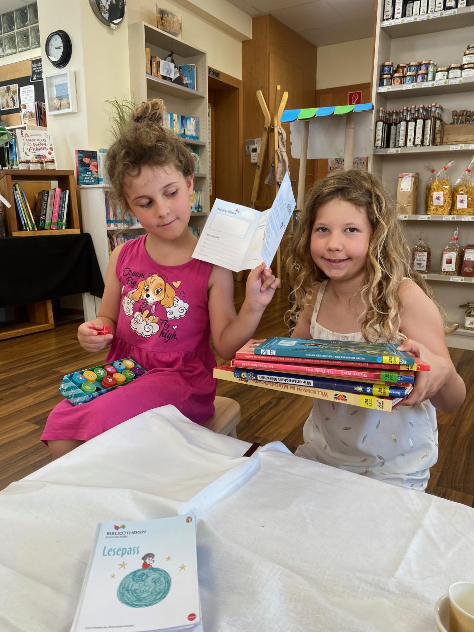 Zwei Mädchen in der Bibliothek mit Büchern