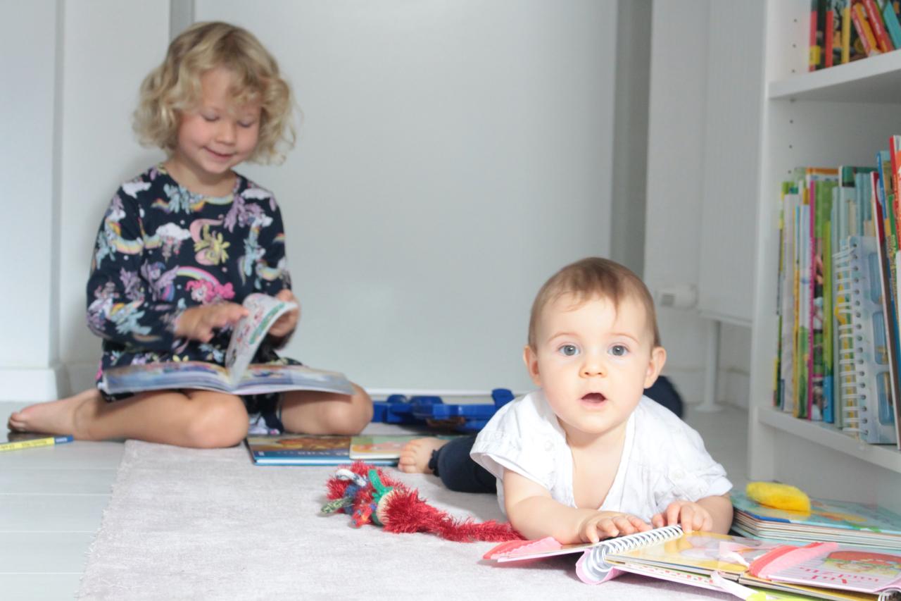 Zwei Kinder bei einem Bücherregal