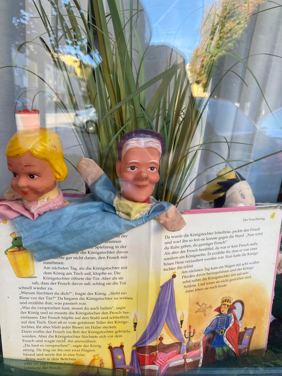 2 Kasperlfiguren und ein Buch in einer Auslage