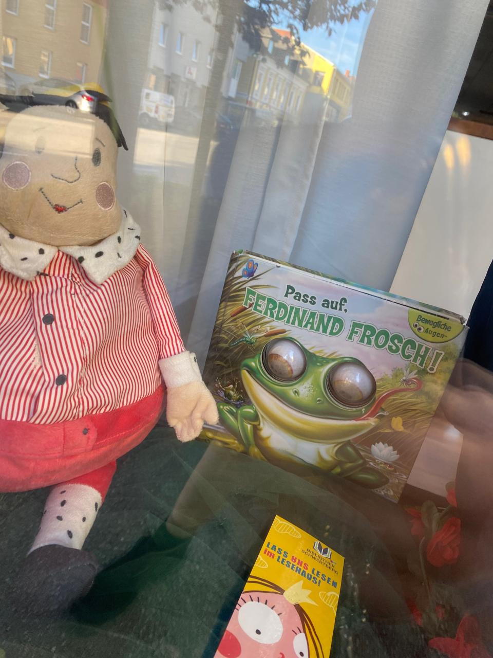Eine Stoffpuppe und ein Buch mit Froschaugen