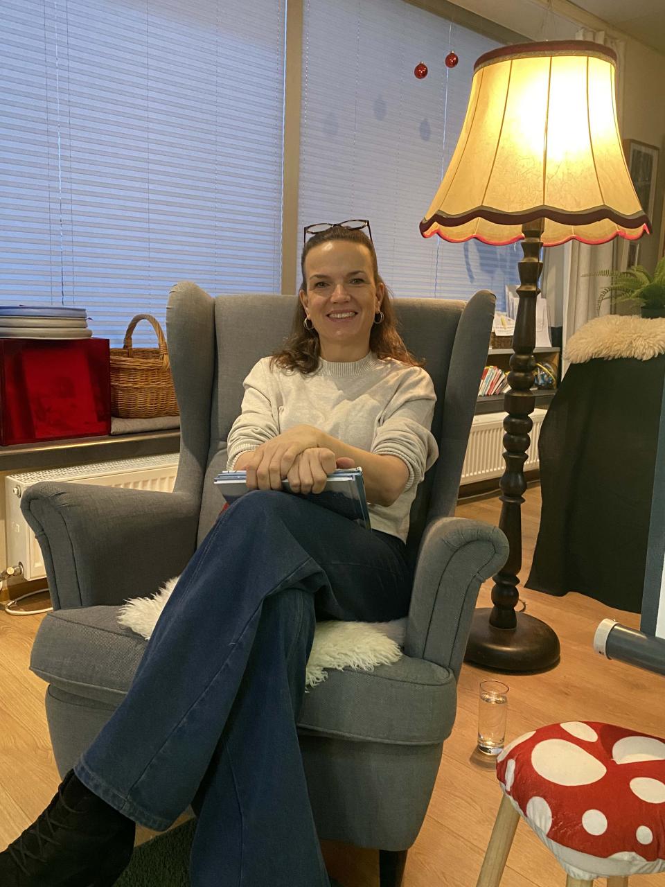 Eine Frau mit Buch auf einem Sessel sitzend