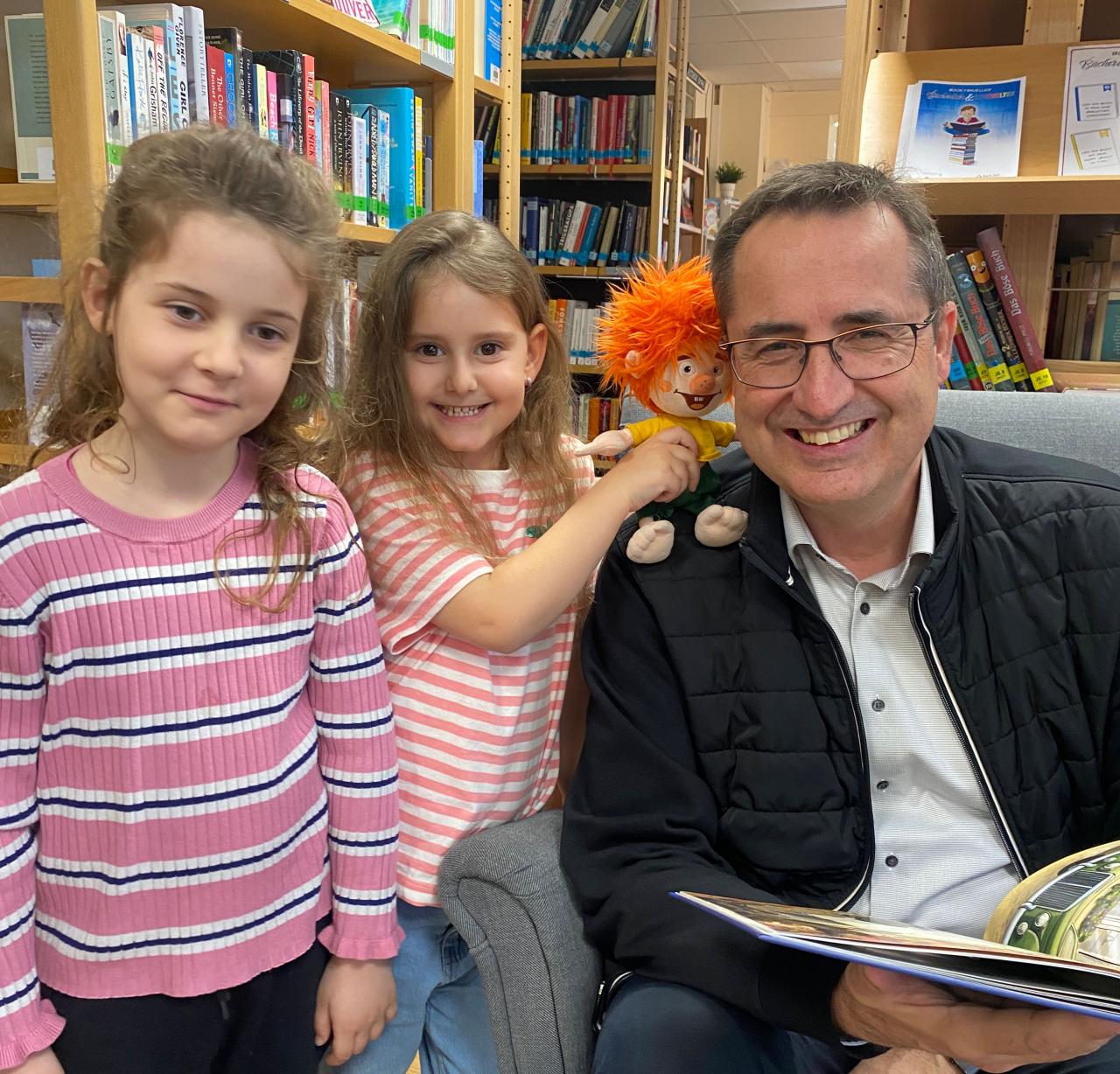 zwei Mädchen mit dem Bürgermeister und einer Stoffpuppe