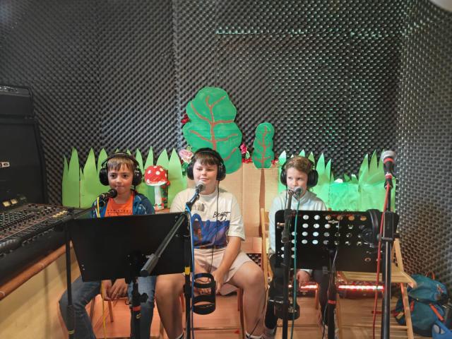 Drei Kinder im Tonstudio vor Mikrofonen