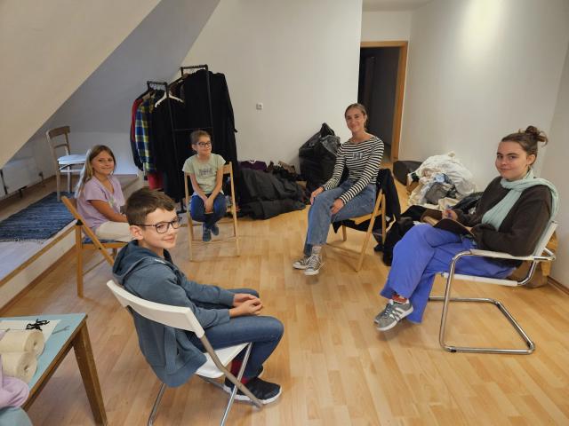 Einige Kinder sitzen auf Sesseln im Kreis