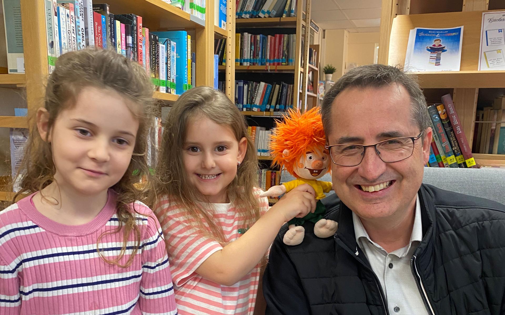 zwei Mädchen mit dem Bürgermeister und einer Stoffpuppe