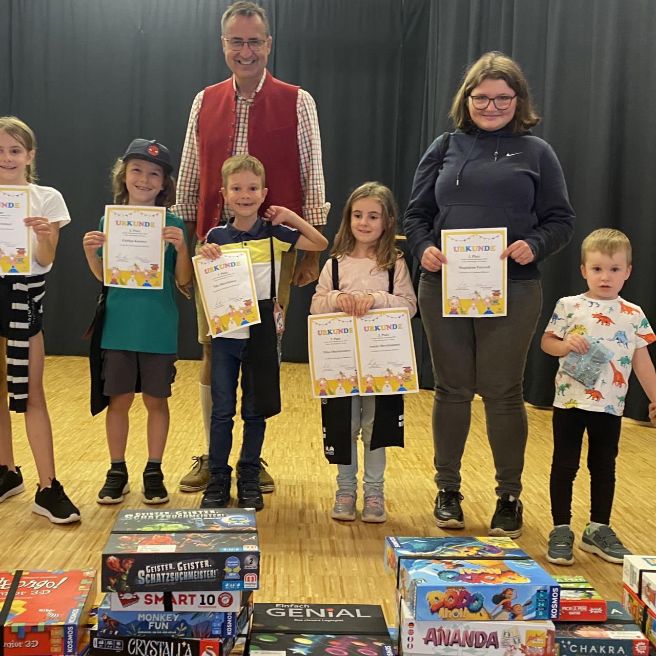 Ein Foto mit Kinder, die eine Urkunde hochhalten