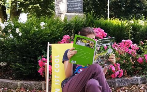 Eine Frau am Liegestuhl mit einem Buch in der Hand