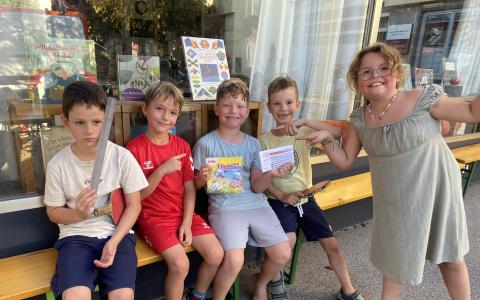 Kinder sitzen vor der Biblitohek