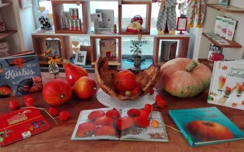 Ein Tisch mit Kürbissen und Herbstbüchern